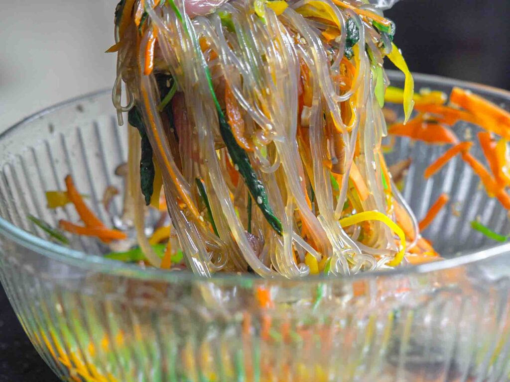 grabbing handful of vegetarian japchae